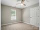Neutral bedroom featuring carpet, a ceiling fan, and a large window at 8309 Emily Dr, Harrisburg, NC 28075