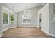Bright dining room with hardwood floors, modern light fixture and views of the neighborhood at 8309 Emily Dr, Harrisburg, NC 28075