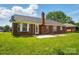Charming brick home exterior featuring a well-maintained lawn and patio, perfect for outdoor gatherings and relaxation at 8309 Emily Dr, Harrisburg, NC 28075