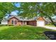Inviting red brick home featuring a two-car garage, neat landscaping, and classic black shutters at 8309 Emily Dr, Harrisburg, NC 28075
