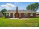 Charming brick home exterior featuring a well-maintained lawn and patio, perfect for outdoor gatherings and relaxation at 8309 Emily Dr, Harrisburg, NC 28075