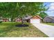 Charming brick home with a well-manicured lawn and a mature shade tree in the front yard at 8309 Emily Dr, Harrisburg, NC 28075