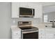 Kitchen with stainless steel oven and microwave, light countertops and white cabinets at 8309 Emily Dr, Harrisburg, NC 28075