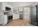 Bright kitchen featuring stainless steel appliances, white cabinets, and an adjacent dining area at 8309 Emily Dr, Harrisburg, NC 28075