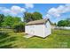 Backyard shed with wood doors and ramp is fenced with green grass at 8309 Emily Dr, Harrisburg, NC 28075
