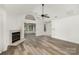 Bright living room featuring hardwood floors, a fireplace, and large windows at 9013 Trellis Pointe Blvd, Charlotte, NC 28227