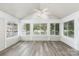 The sunroom has gray laminate flooring, a ceiling fan, and many windows that let in natural light at 9013 Trellis Pointe Blvd, Charlotte, NC 28227