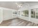 The sunroom has gray laminate flooring, a ceiling fan, and many windows that let in natural light at 9013 Trellis Pointe Blvd, Charlotte, NC 28227