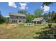 Expansive backyard with a charming fire pit area, a playhouse, and a well-maintained lawn at 9115 Providence S Rd, Waxhaw, NC 28173
