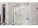 Bathroom showcasing an enclosed shower with built in shelves, stainless hardware, and sleek glass door at 9115 Providence S Rd, Waxhaw, NC 28173