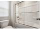 Clean bathroom featuring a modern toilet and a sleek bathtub-shower combo with glass sliding door at 9115 Providence S Rd, Waxhaw, NC 28173