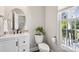 Elegant powder room with a modern vanity, round mirror, and natural light from the window at 9115 Providence S Rd, Waxhaw, NC 28173