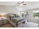 Vaulted bedroom features a large bed with storage, dual nightstands, and a ceiling fan with light fixture at 9115 Providence S Rd, Waxhaw, NC 28173