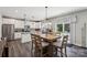 Dining area next to kitchen featuring a wooden table, modern pendant lights, and backyard views at 9115 Providence S Rd, Waxhaw, NC 28173