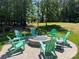 Outdoor fire pit area surrounded by green Adirondack chairs perfect for entertaining at 9115 Providence S Rd, Waxhaw, NC 28173