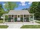 Charming playhouse offers covered porch with rocking chairs and swing, nestled among the trees at 9115 Providence S Rd, Waxhaw, NC 28173