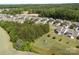 Picturesque aerial view of a residential community showcasing well-maintained homes nestled among lush green trees and landscaping at 9871 Travertine Trl, Davidson, NC 28036