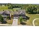Aerial view of a brick two-story home featuring a well-manicured lawn, two-car garage, and beautiful landscaping at 9871 Travertine Trl, Davidson, NC 28036