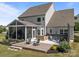 Inviting back patio boasts a hot tub, fire pit, and screened-in porch with outdoor seating under cafe-style lights at 9871 Travertine Trl, Davidson, NC 28036