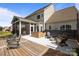 Inviting back patio boasts a hot tub, fire pit, and screened-in porch with outdoor seating under cafe-style lights at 9871 Travertine Trl, Davidson, NC 28036