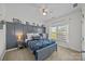 Relaxing bedroom with decorative wall paneling, a cozy bed, and bright natural light at 9871 Travertine Trl, Davidson, NC 28036