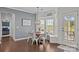 Charming breakfast nook with bay window, white trim, hardwood floors, and modern light fixture at 9871 Travertine Trl, Davidson, NC 28036