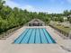 A sparkling community pool is surrounded by lush greenery, featuring plenty of seating and shaded areas for relaxation at 9871 Travertine Trl, Davidson, NC 28036