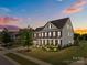 Charming brick two-story home with a welcoming front porch and meticulously landscaped front yard at 9871 Travertine Trl, Davidson, NC 28036