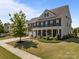 Beautiful brick two-story home with a covered front porch and well-manicured landscaping at 9871 Travertine Trl, Davidson, NC 28036