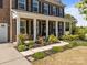 Inviting covered front porch with elegant columns and colorful landscaping along the walkway at 9871 Travertine Trl, Davidson, NC 28036