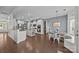 Open kitchen and breakfast nook boasts white cabinets, stainless steel appliances, and hardwood floors at 9871 Travertine Trl, Davidson, NC 28036