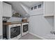 Convenient laundry room featuring modern washer and dryer with ample storage space and folding area at 9871 Travertine Trl, Davidson, NC 28036