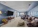 Spacious living room features plush seating, television, and bright natural light from the many windows at 9871 Travertine Trl, Davidson, NC 28036