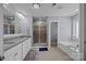 The main bathroom features a walk-in shower, granite counters, and an attached soaking tub room at 9871 Travertine Trl, Davidson, NC 28036
