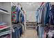 This walk-in closet features two rows of clothing, shoes, and a decorative chandelier at 9871 Travertine Trl, Davidson, NC 28036