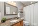 Bathroom featuring granite countertop, wood cabinets, and decorative mirror at 10421 Columbia Crest Ct, Charlotte, NC 28270