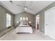 Well-lit bedroom with a ceiling fan, neutral colors, and three framed decorations at 10421 Columbia Crest Ct, Charlotte, NC 28270