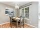 Cozy dining room with wood floors, modern lighting fixture, and an bright window with white blinds at 10421 Columbia Crest Ct, Charlotte, NC 28270