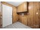 Practical laundry room with wood paneling, upper cabinets, and a utility sink at 105 Carrie Ln # 3, Cherryville, NC 28021
