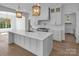 Bright kitchen with white cabinetry, a large island with a sink, pendant lights, and stainless steel appliances at 114 Wilharr Ct # 38, Mooresville, NC 28115