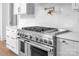 A close-up of a gourmet kitchen featuring a gas range, pot filler faucet, and white shaker cabinets at 114 Wilharr Ct # 38, Mooresville, NC 28115