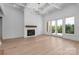 Bright living room with a white brick fireplace, hardwood floors, and windows with natural light at 114 Wilharr Ct # 38, Mooresville, NC 28115