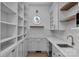 Pantry with custom shelving, white cabinetry, ample storage and a circular window that brings in natural light at 114 Wilharr Ct # 38, Mooresville, NC 28115