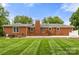 Brick home exterior featuring a spacious deck and patio area for outdoor relaxation and enjoyment at 12117 Idlewild Rd, Matthews, NC 28105