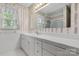 Clean bathroom with a long white countertop and a window with patterned curtains at 12117 Idlewild Rd, Matthews, NC 28105