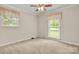 Serene bedroom featuring neutral walls, carpet, and bright natural light from two windows at 12117 Idlewild Rd, Matthews, NC 28105