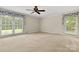 Spacious bedroom with carpet, a ceiling fan, and large windows providing ample light at 12117 Idlewild Rd, Matthews, NC 28105