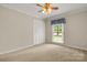 Neutral bedroom with wall-to-wall carpet, closet, and a window with blue curtains at 12117 Idlewild Rd, Matthews, NC 28105