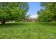 Well-maintained front yard with lush lawn and a home framed by mature trees at 12117 Idlewild Rd, Matthews, NC 28105