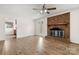 Cozy living room featuring hardwood floors, a brick fireplace, and view into the kitchen at 12117 Idlewild Rd, Matthews, NC 28105